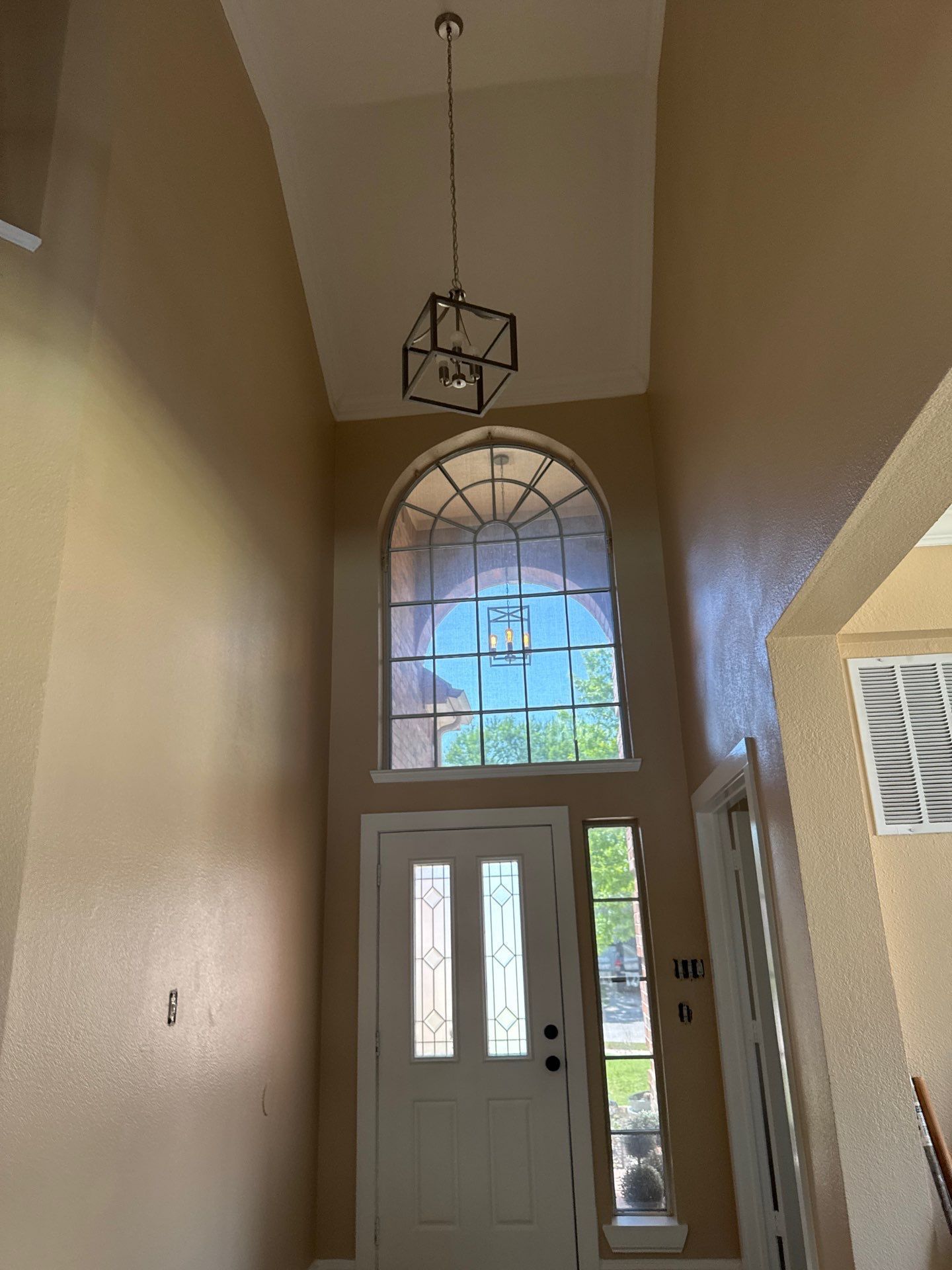 A hallway with a white door and a large window.
