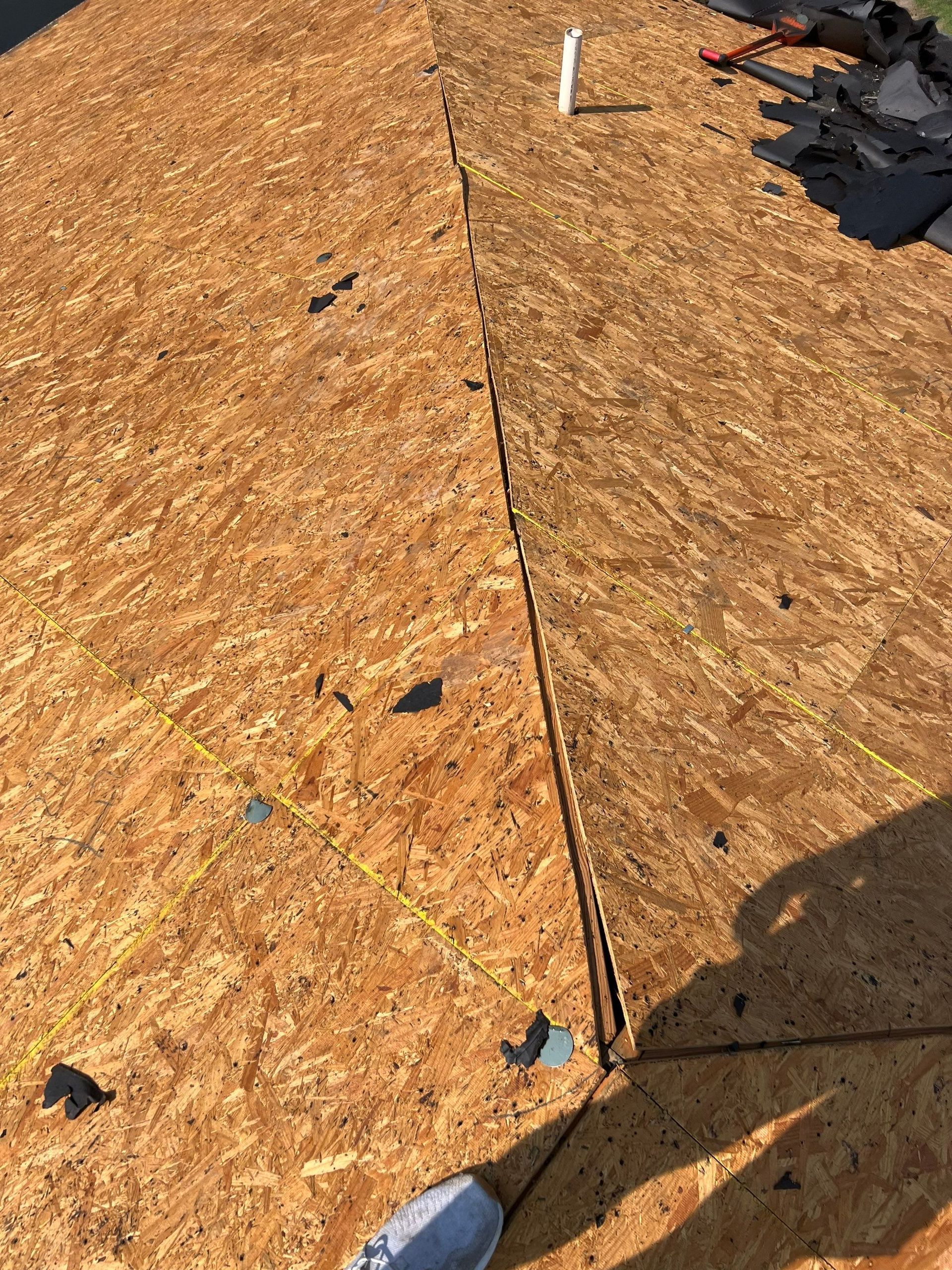 A person is standing on top of a wooden roof.