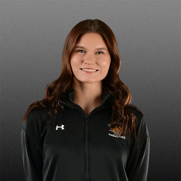 Smiling person in a black zip-up jacket against a gray background