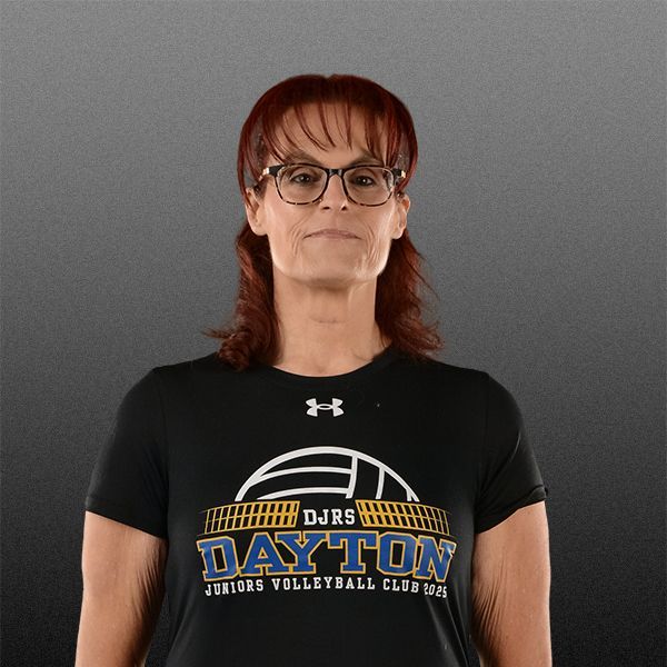 Person wearing glasses and a black Dayton T-shirt, standing against a gray background.