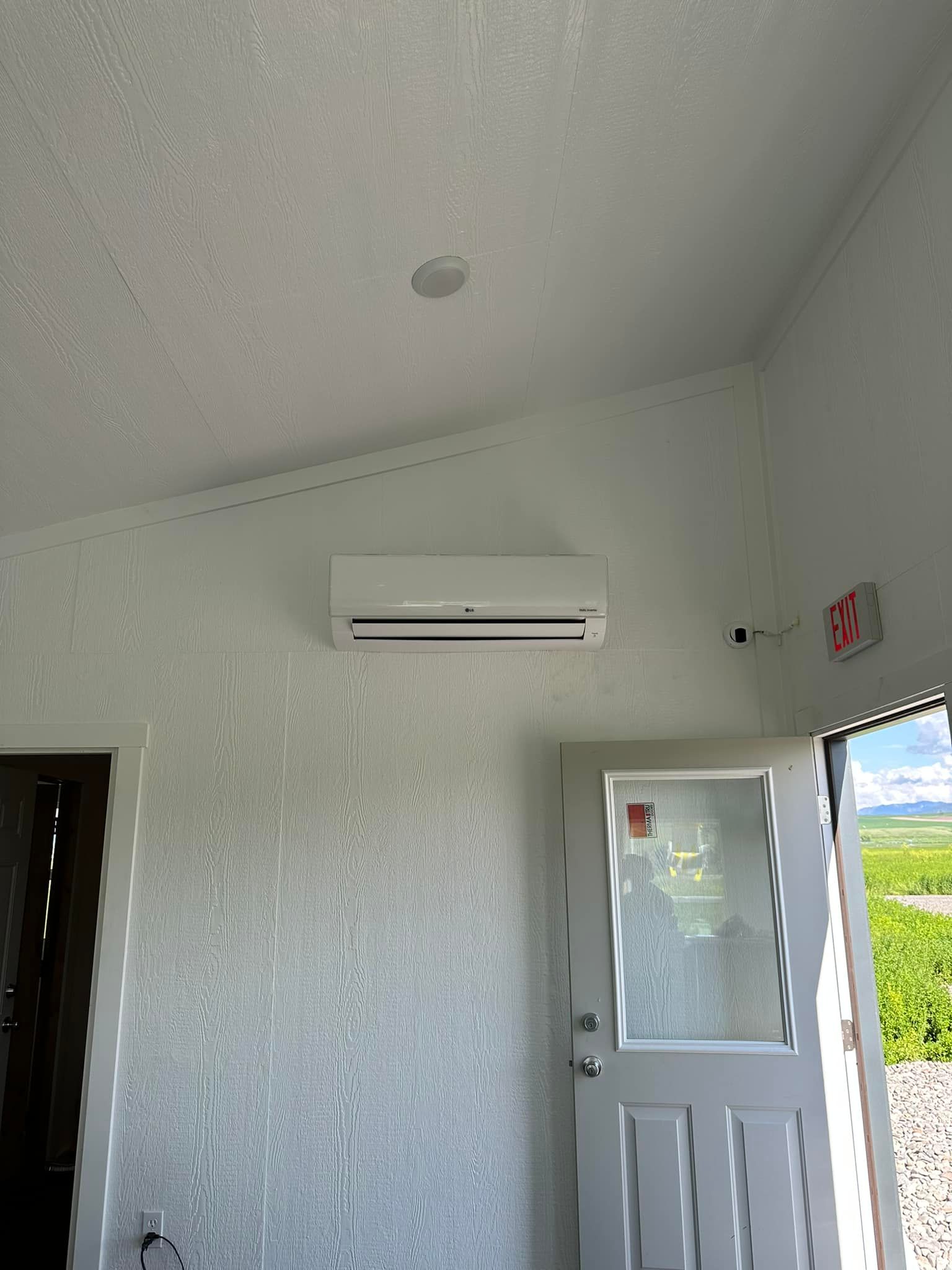 A room with a door and a wall mounted air conditioner.