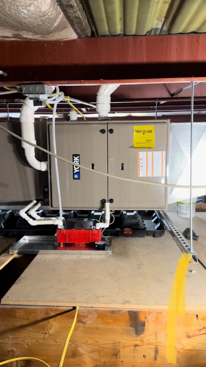 An air conditioner is hanging from the ceiling of a building.