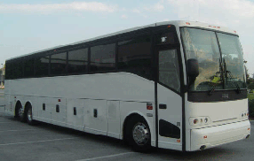White tour bus parked on a lot, viewed from the front-left side.
