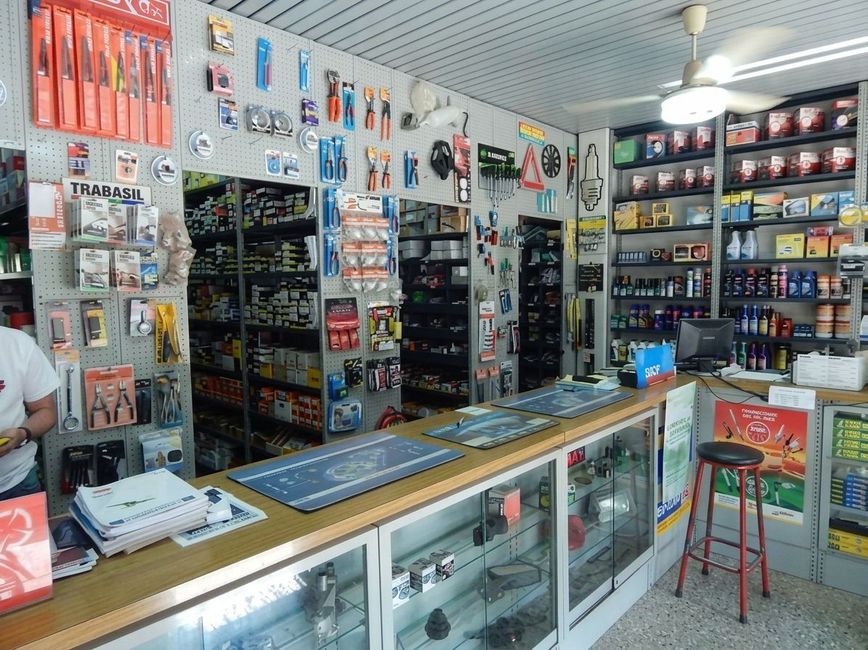 Tienda de pequeños aparatos electrónicos y accesorios para teléfonos con vitrinas de cristal y estantes llenos de productos coloridos.