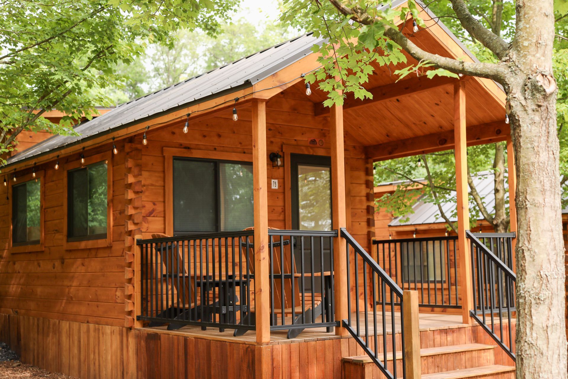 A small wooden cabin with a porch and stairs.