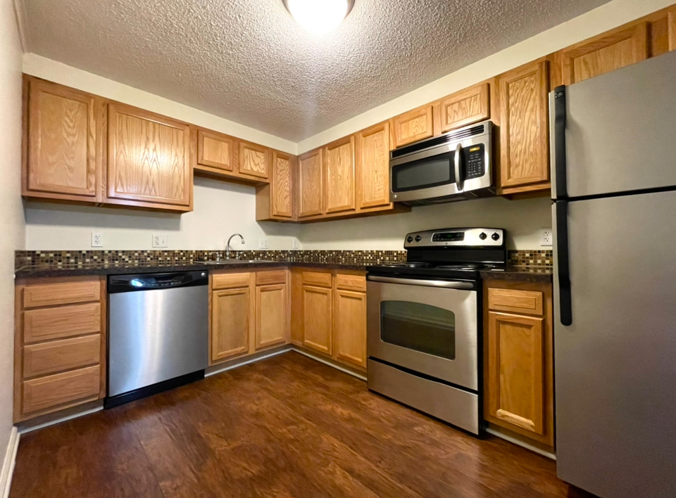 A kitchen with stainless steel appliances and wooden cabinets