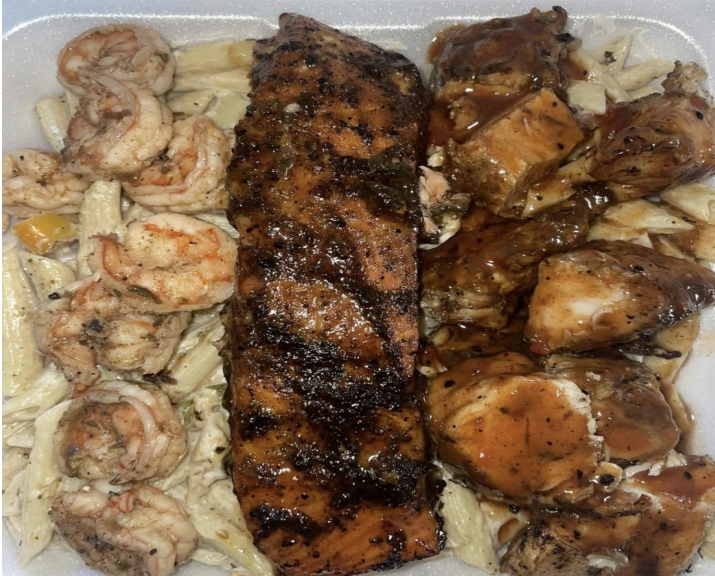 Takeout container with grilled salmon, shrimp, and teriyaki chicken over noodles.