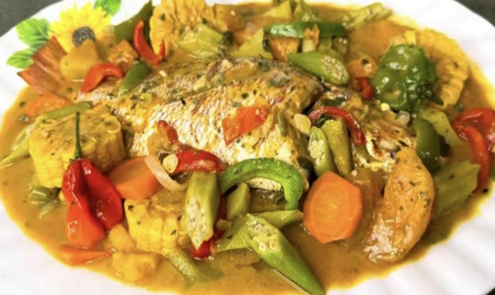 Vegetable stew with carrots, green peppers, zucchini, and red peppers served on a white plate