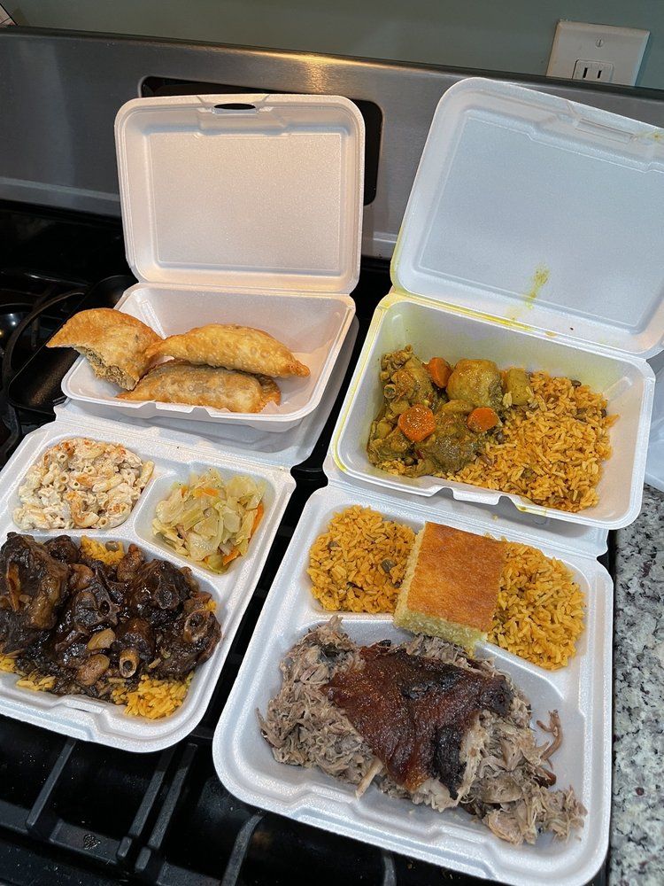 Takeout containers with assorted food, including rice, chicken, and fried items, on a table