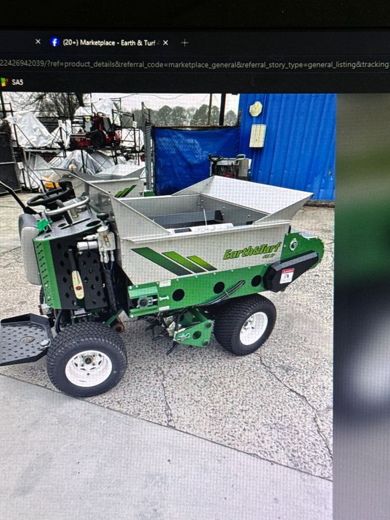 Green autonomous utility robot with a metal bin indoors on a concrete floor