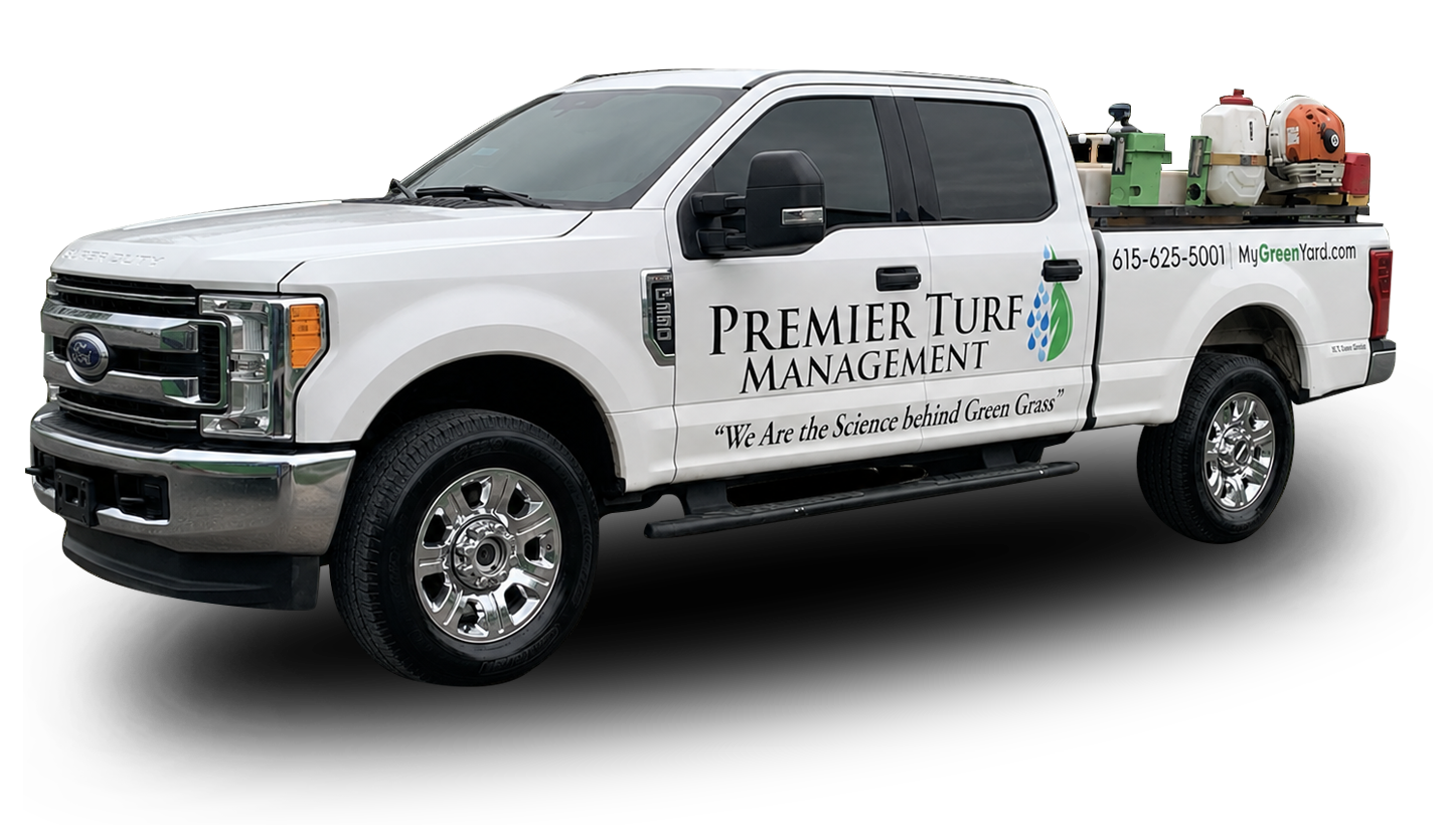 White service truck with “Premier Turf Management” logo and landscaping equipment in the back