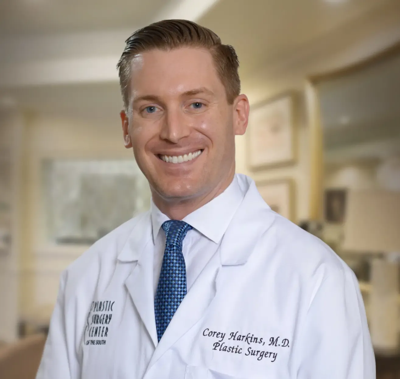 A smiling doctor in a white coat and tie, with 