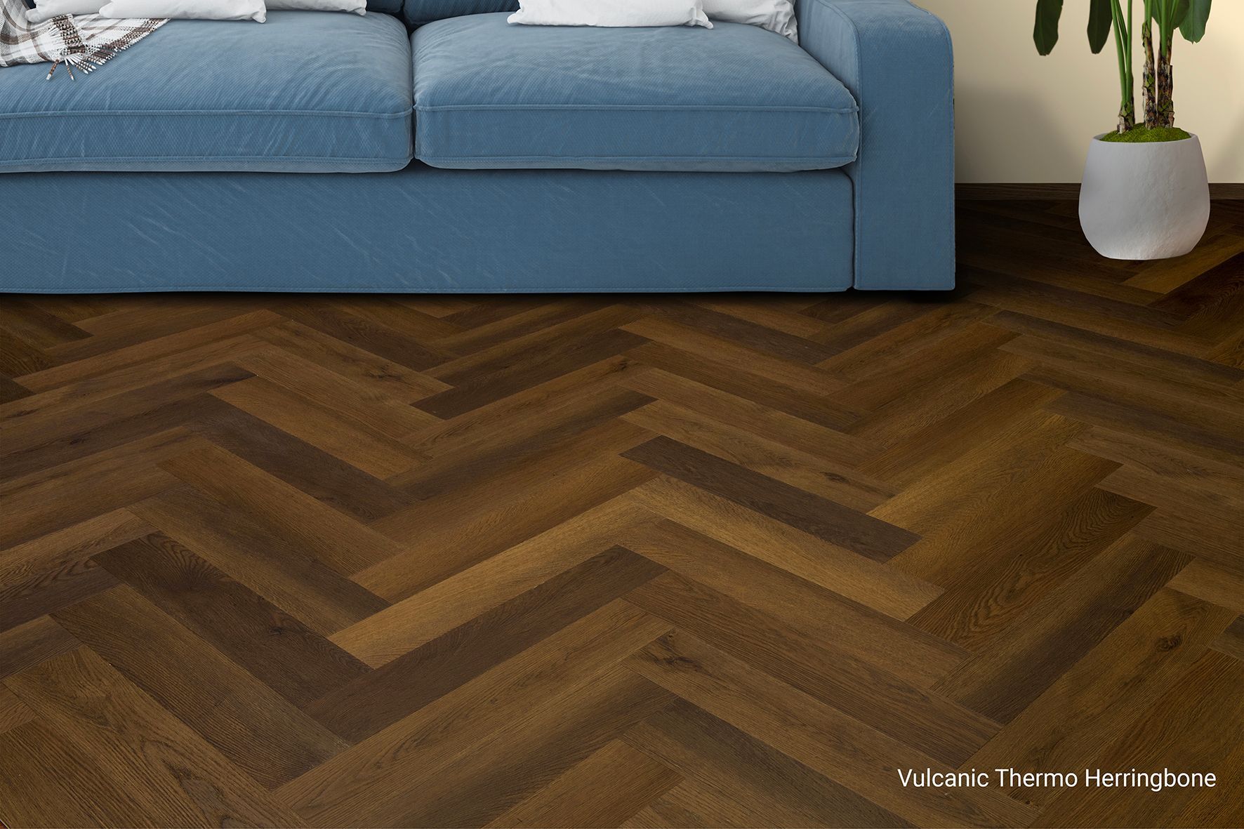 Sofá azul sobre suelo de madera oscura en espiga en un salón moderno.
