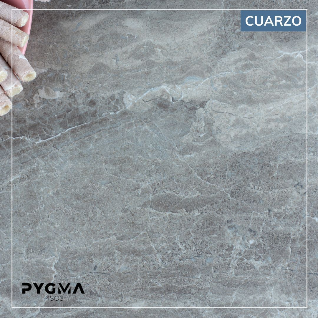 Muestra de losa de cuarzo gris con vetas sutiles, etiquetada como “CUARZO” y “PYGMA”.
