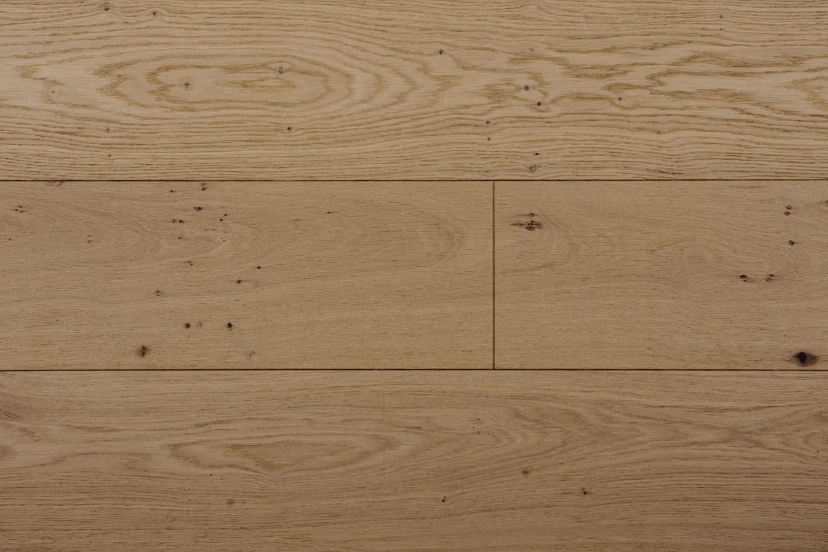 Superficie de madera de color marrón claro con vetas visibles y algunos nudos y marcas oscuras.