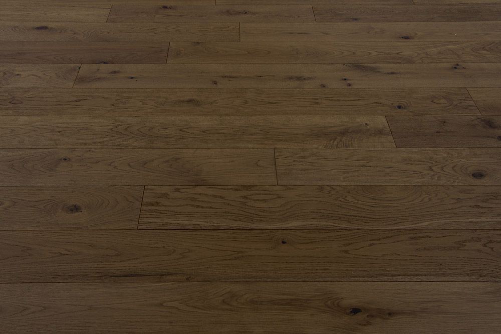 Primer plano de un suelo de madera marrón oscuro con tablones y vetas visibles.