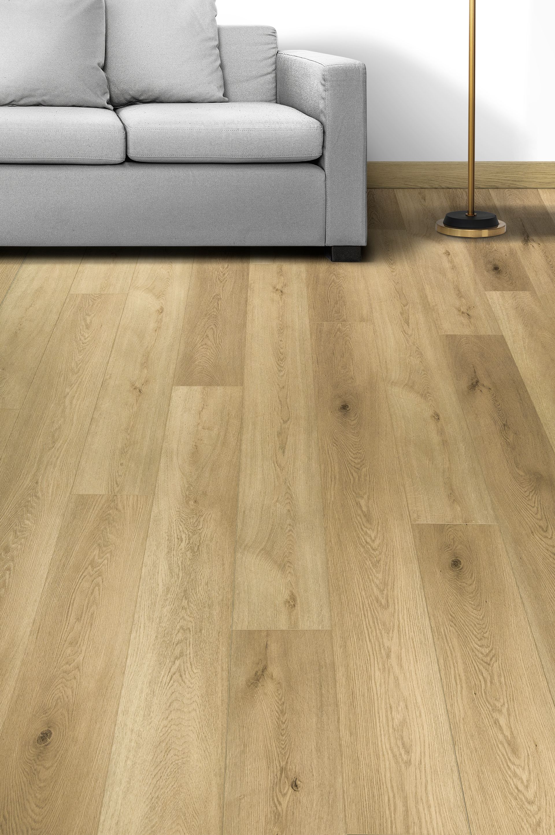 Sala de estar con sofá gris, lámpara de pie y suelo de madera clara.