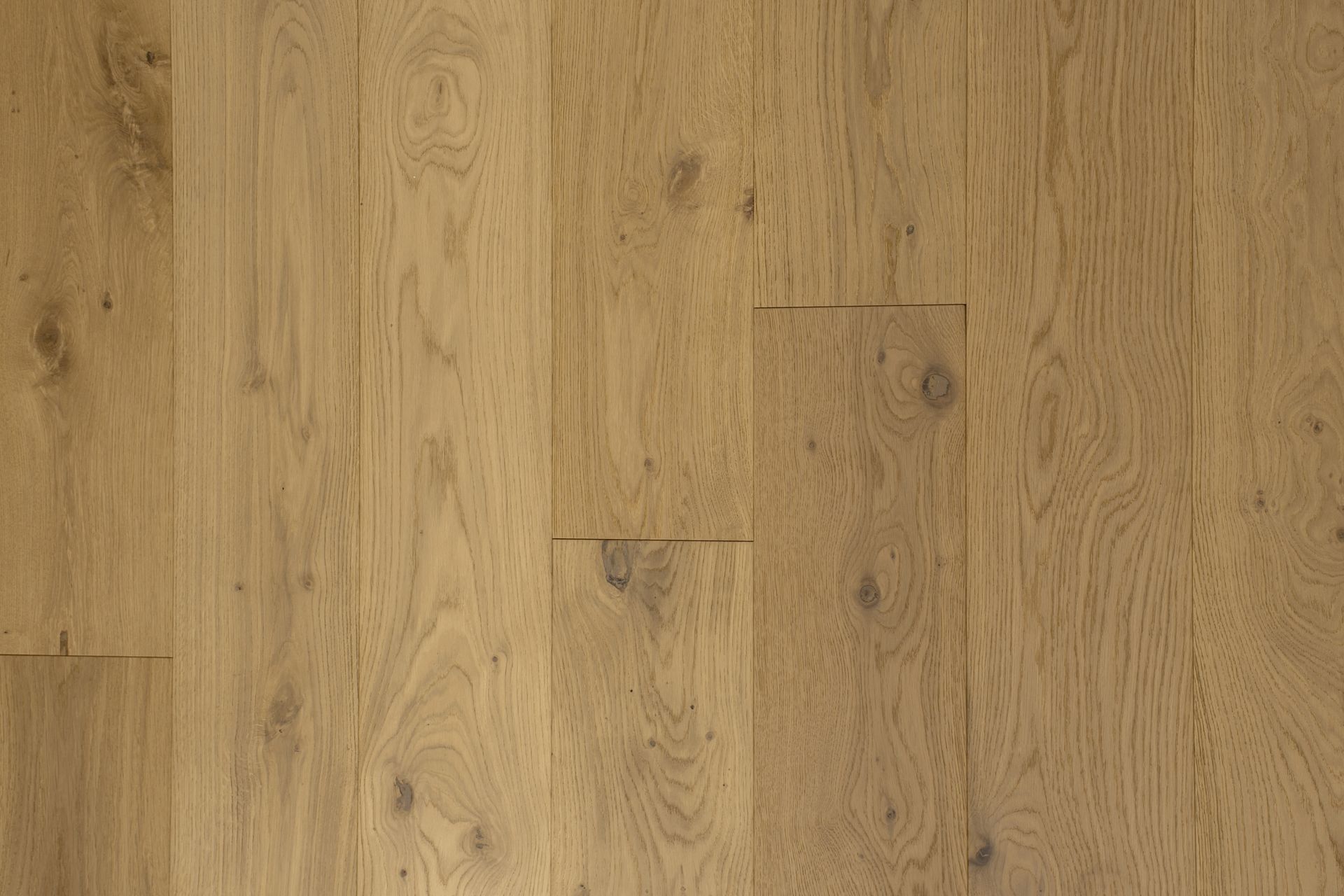 Suelo de tablones de madera de roble claro con nudos y vetas visibles.