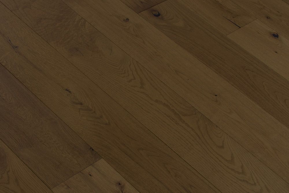 Primer plano de un suelo de madera marrón con tablones diagonales y vetas visibles.