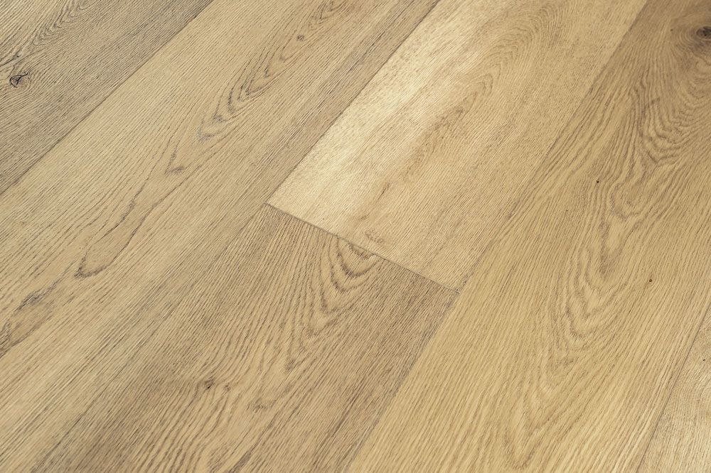 Suelo de madera clara con patrones de tablones diagonales y acabado de veta natural.
