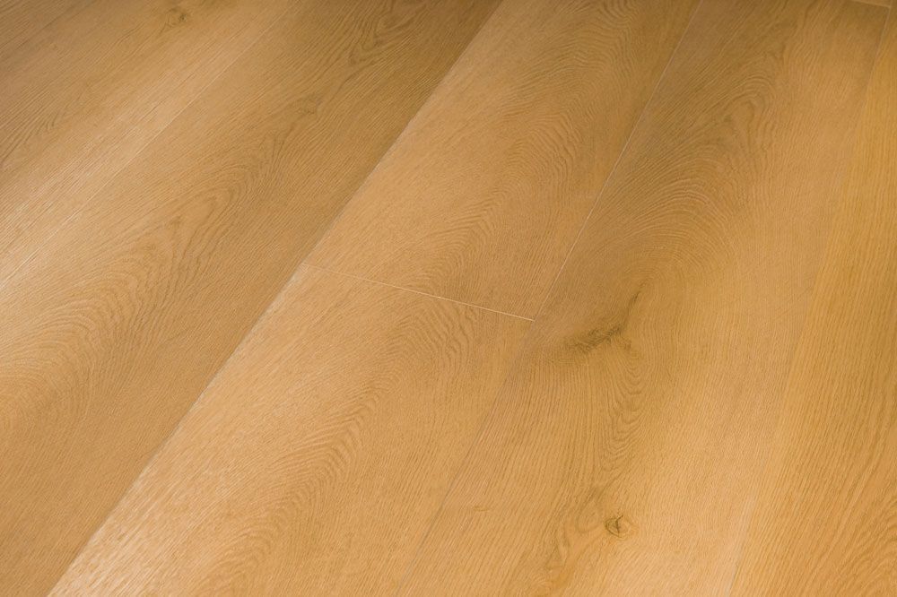Primer plano de tablones de madera clara con veta visible y tonos beige cálidos.