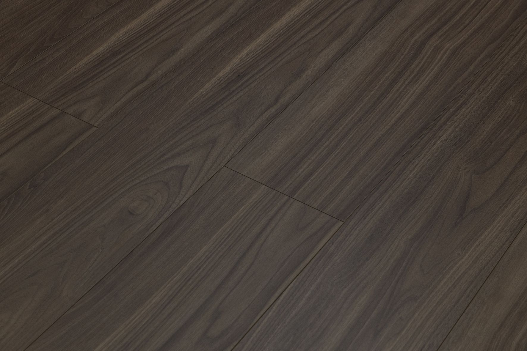 Primer plano de un suelo de madera oscura con vetas diagonales.