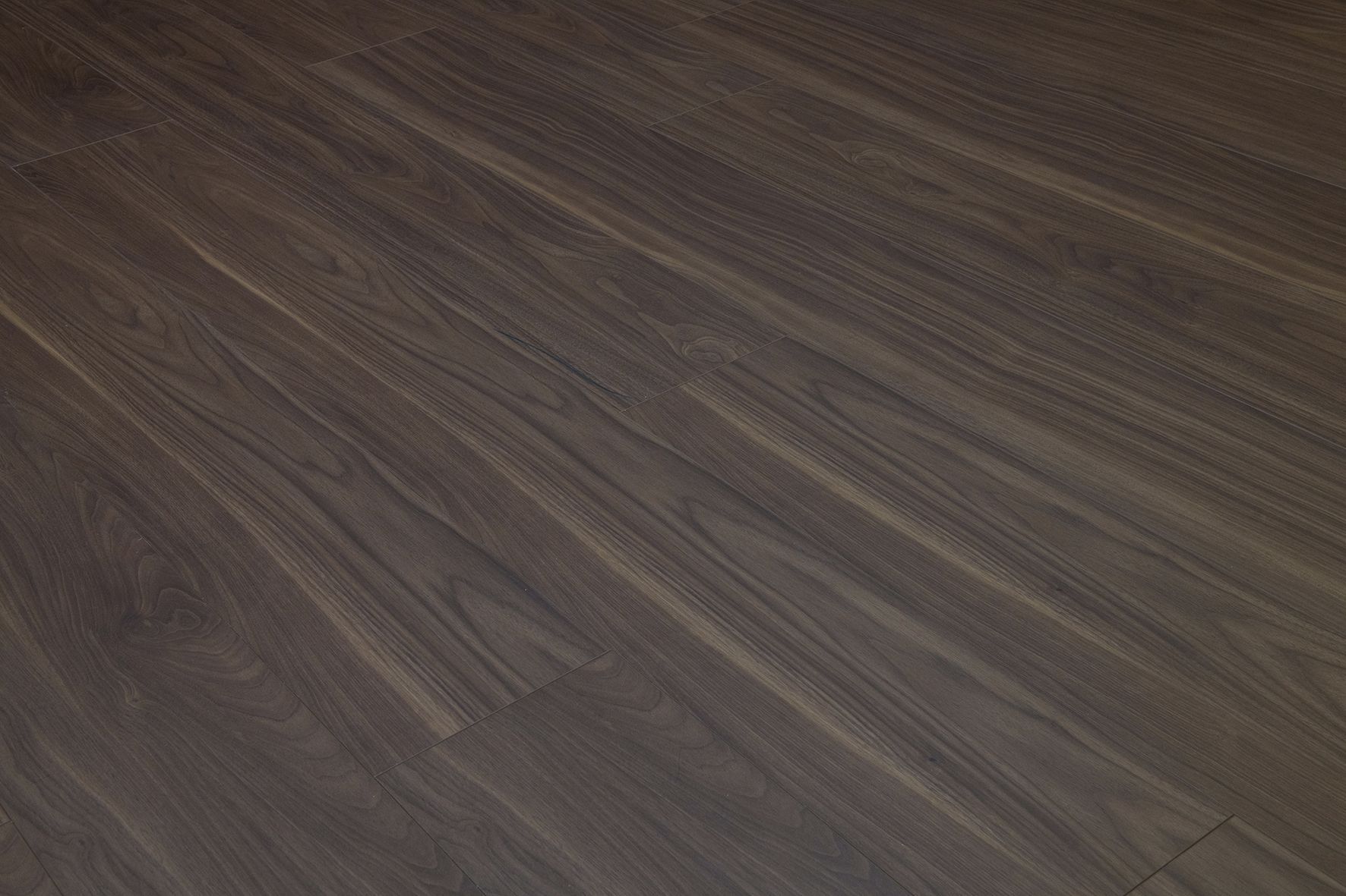 Primer plano de una superficie de suelo de madera de color marrón oscuro.