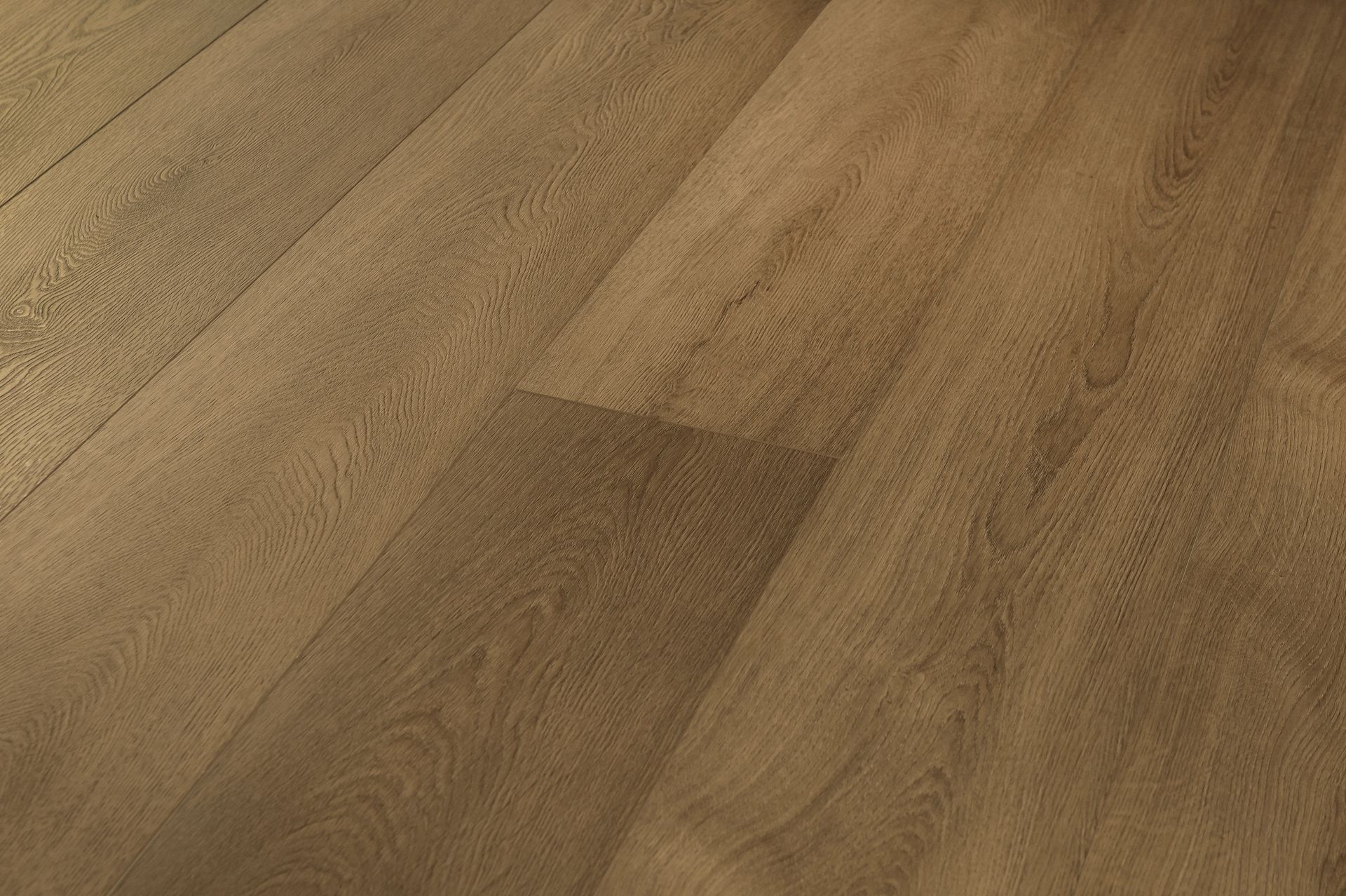 Primer plano de un suelo de madera de color marrón claro con juntas de tablones y textura de vetas.