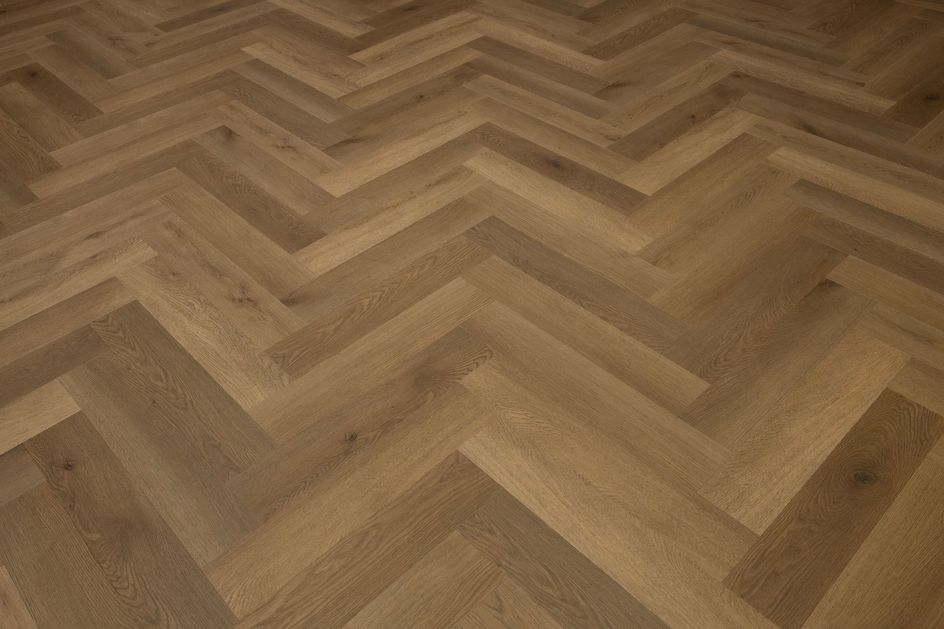 Suelo de madera con diseño de espiga en tonos marrones cálidos.