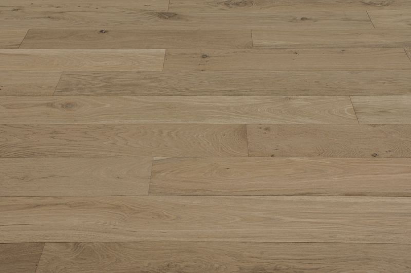 Suelo de tablones de madera clara con veta horizontal y juntas sutiles.