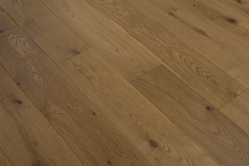 Suelo de tablones de madera de color marrón claro con vetas y nudos visibles.