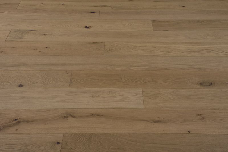 Suelo de tablones de madera de color marrón claro con vetas y nudos visibles.