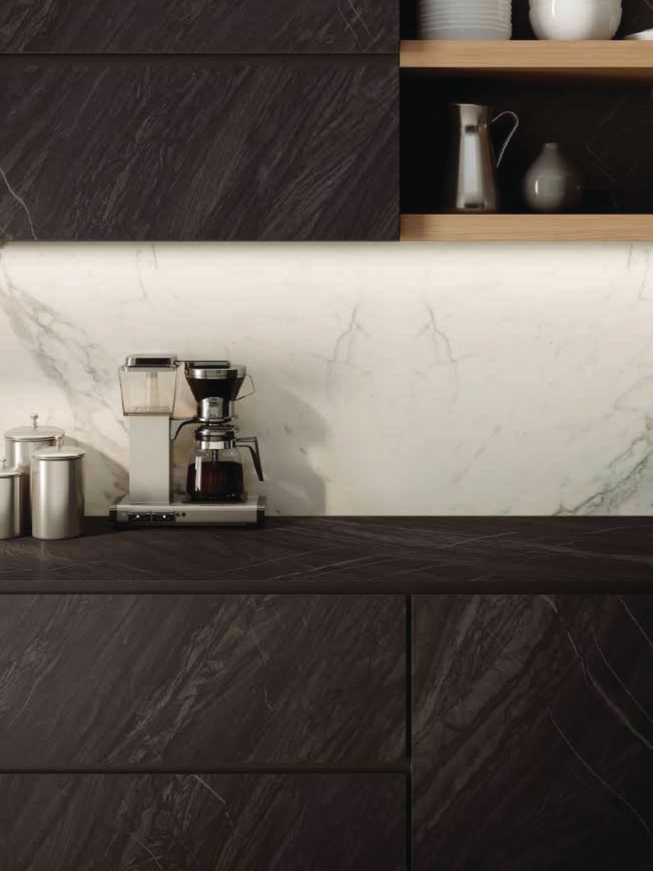 Cocina moderna con gabinetes de madera oscura, salpicadero de mármol blanco y cafetera en la encimera.