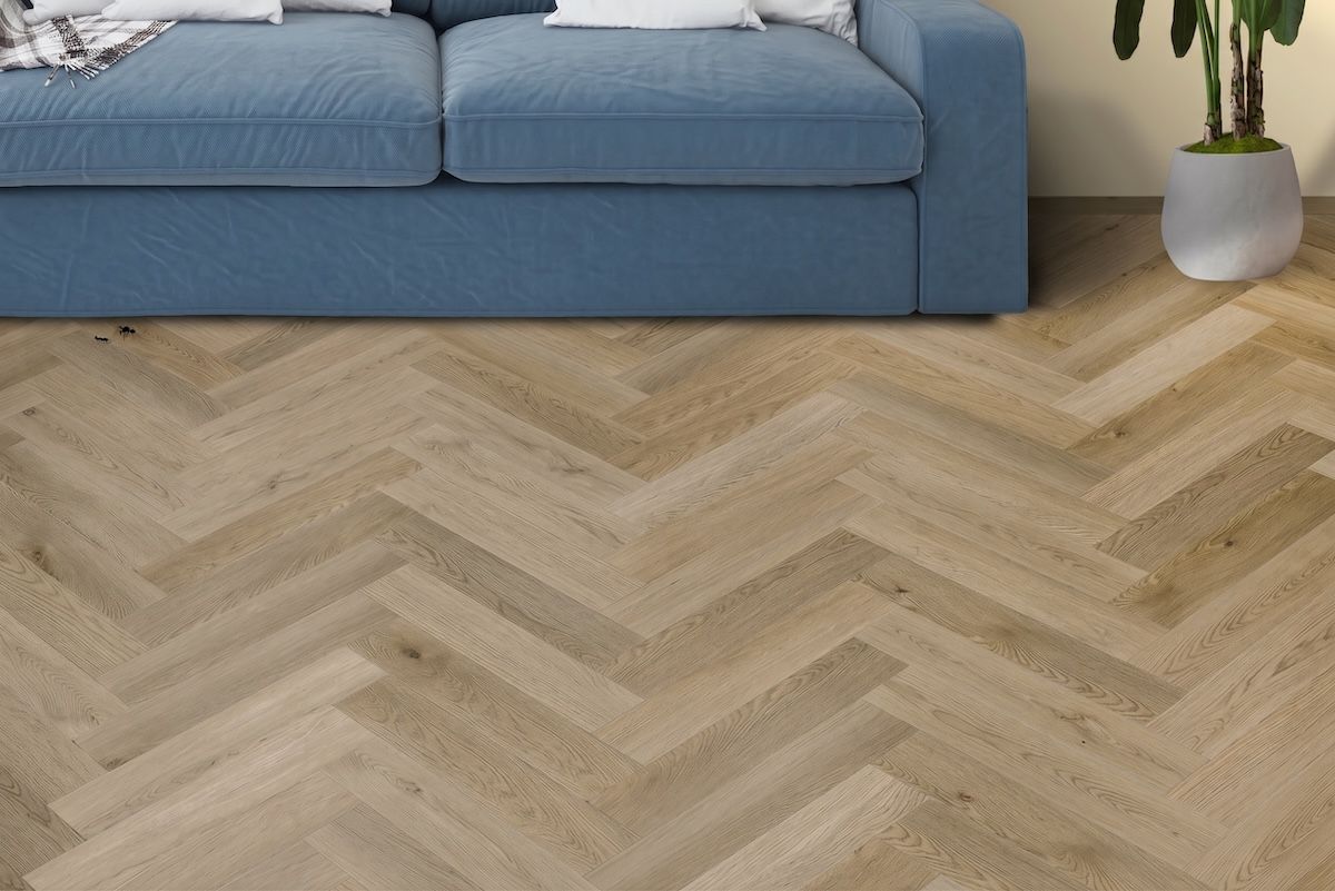 Suelo de madera clara con diseño de espiga en tonos tostados y beige.