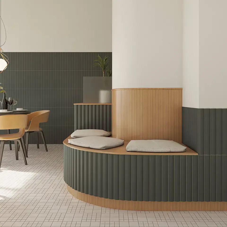 Rincón de cafetería moderno con banco curvo verde, paneles de madera y mesas de comedor en un interior minimalista.