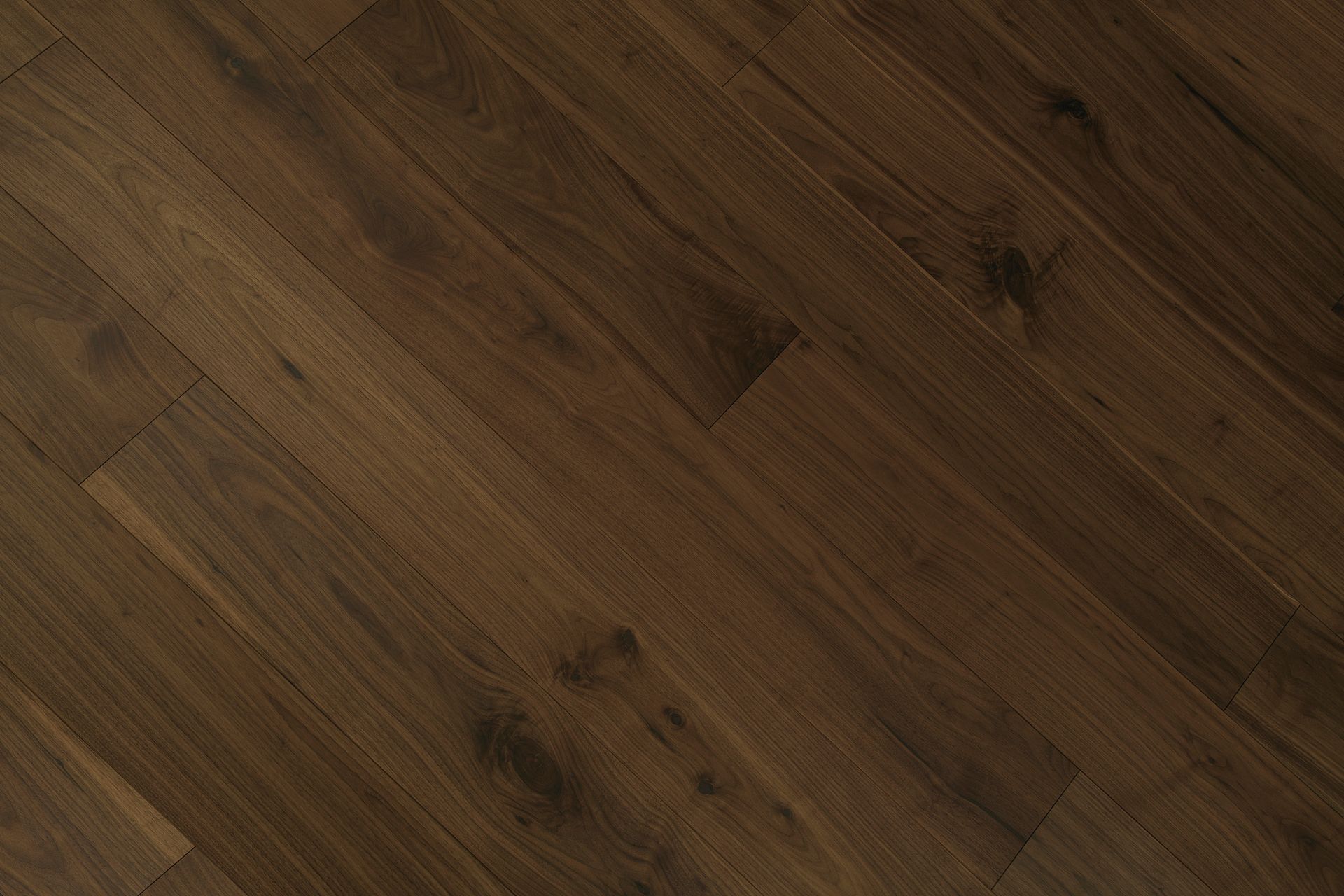 Suelo de tablones de madera de color marrón oscuro con vetas y nudos visibles.