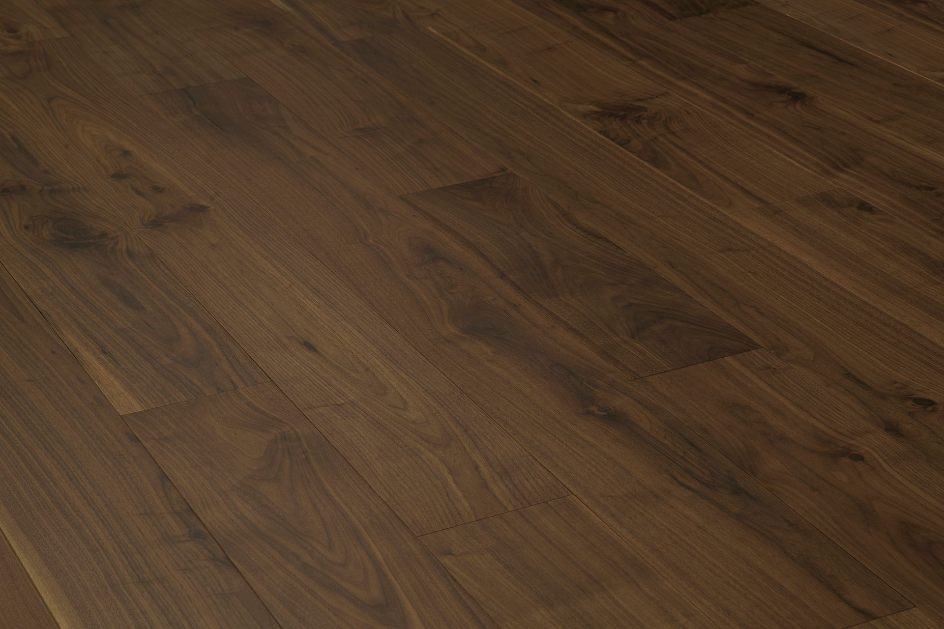 Suelo de tablones de madera marrón con vetas diagonales.