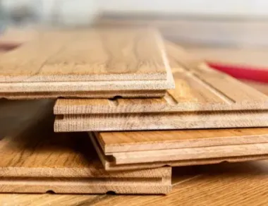 Tablones de madera clara apilados sobre una superficie de madera, primer plano.