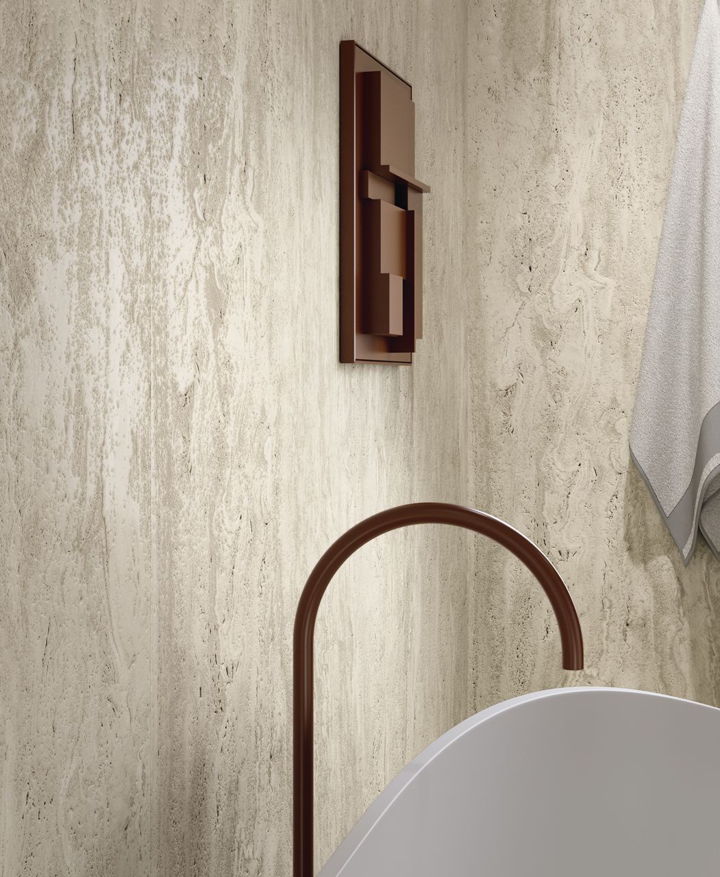 Baño moderno con pared texturizada de color beige, aplique de pared y grifo curvo marrón sobre un lavabo blanco.