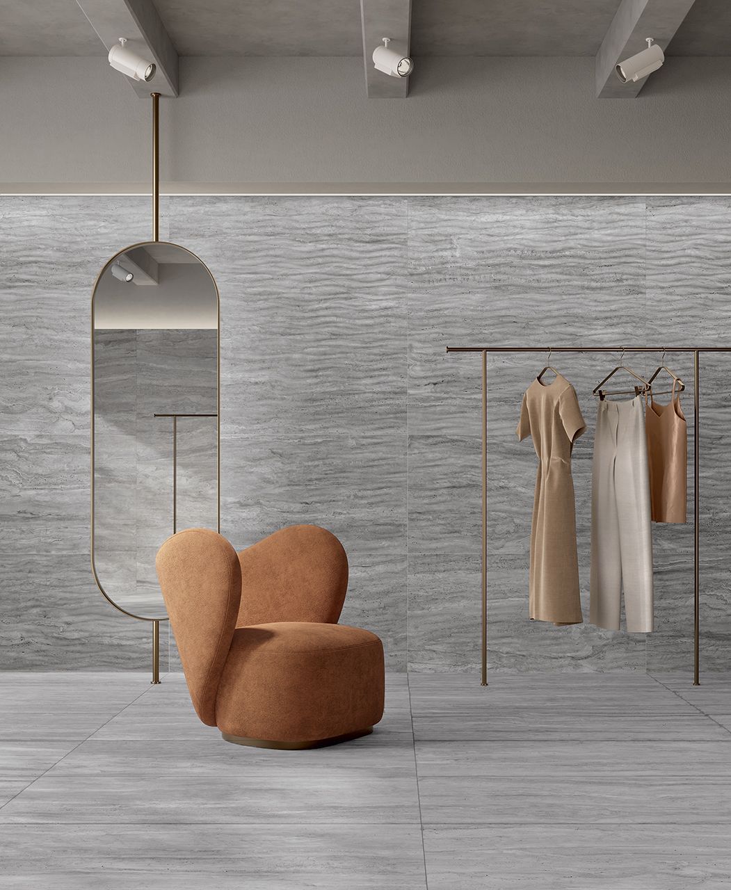Boutique de ropa minimalista con silla beige, espejo de cuerpo entero y perchero con prendas de tonos neutros sobre paredes grises.