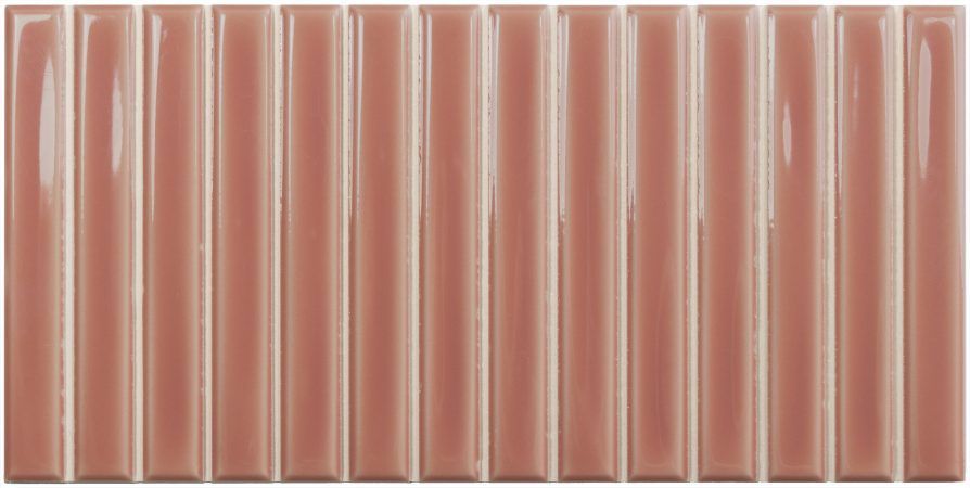 Hilera de tubos cilíndricos acanalados de color rosa alineados uno al lado del otro sobre un fondo blanco.