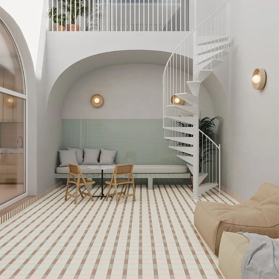 Luminoso salón tipo loft minimalista con escalera de caracol blanca, sofá empotrado en un arco y suelo de baldosas.