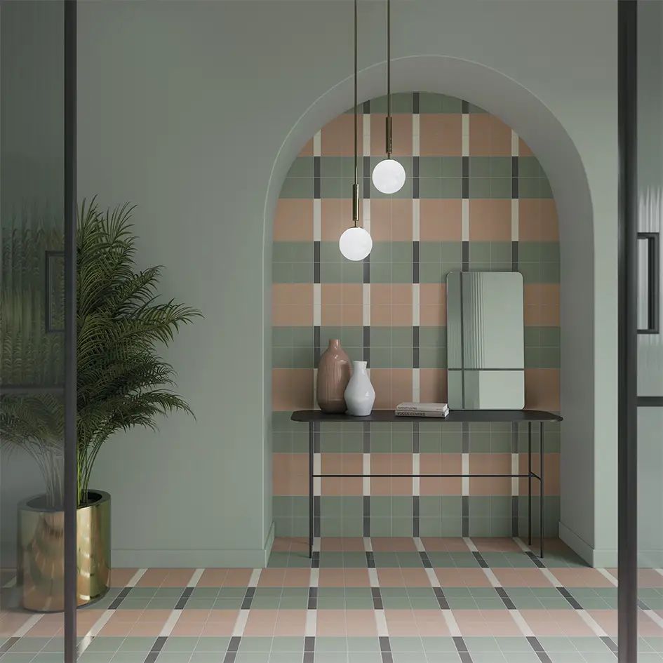 Pasillo moderno con arco, azulejos a cuadros rosas y verdes, lámparas colgantes, mesa consola, espejo y planta en maceta.