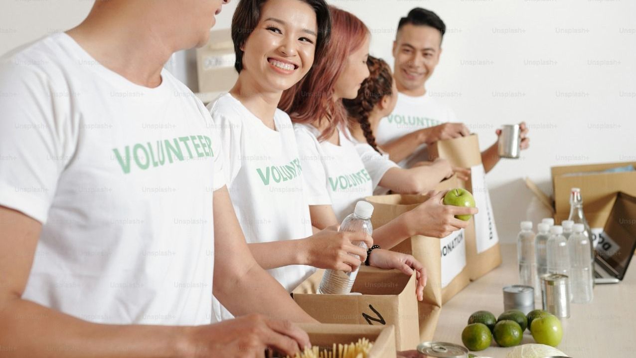 A group of volunteers are standing around a table.
