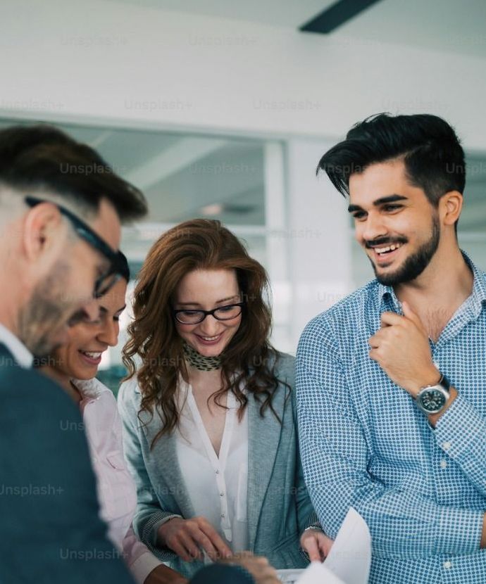 A group of people are standing around a table looking at a piece of paper.