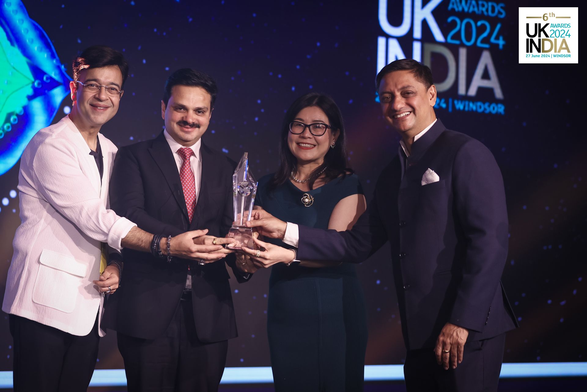 A group of people are standing next to each other holding a trophy.