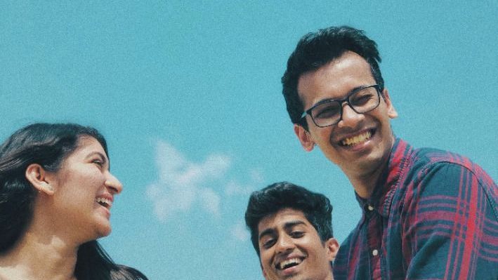 A group of young people are standing next to each other and smiling.