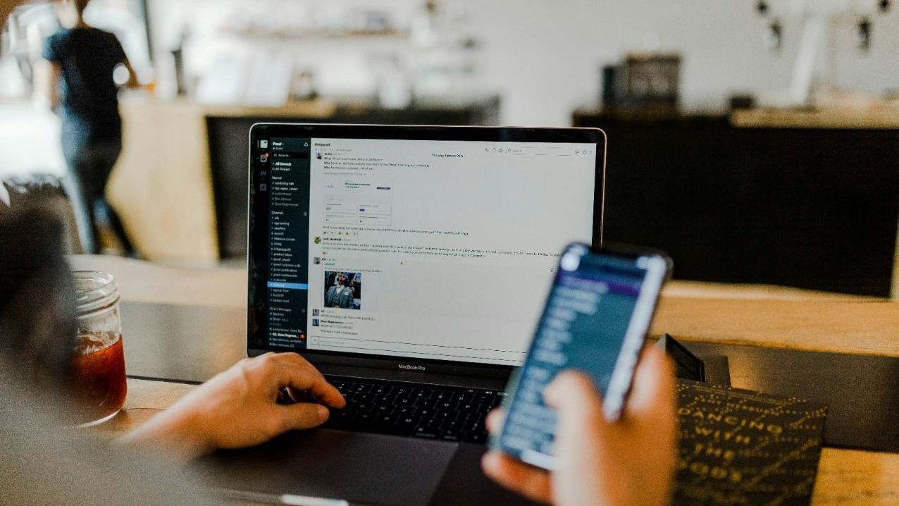 A person is using a laptop and a cell phone at the same time.