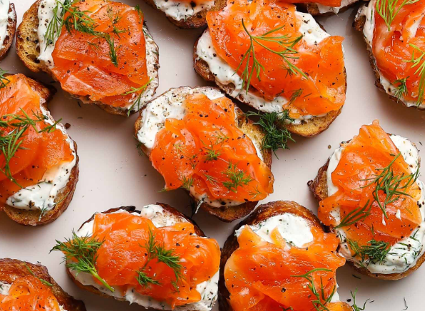 Smoked salmon and cream cheese on rye crackers, topped with dill