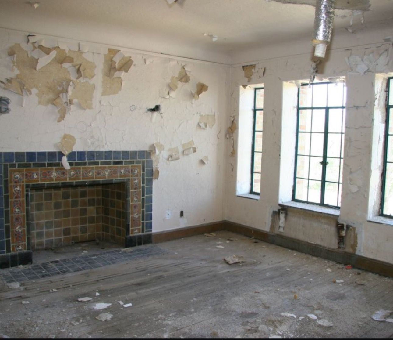 An empty room with a fireplace and windows
